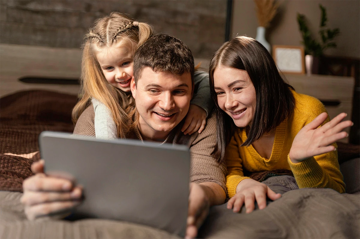Famiglia con genitori e figla che guardano il telefono